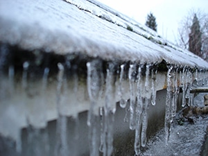 Icicle formation on the roof edges and frozen gutters